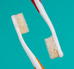 Two mouthwatchers toothbrushes face to face 